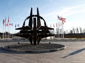 FILE PHOTO: A man stands outside NATO headquarters in Brussels, Belgium on January 6, 2020.