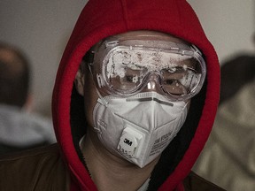 A man wears a protective mask and goggles as he lines up to check in to a flight at Beijing Capital Airport on Jan. 30, 2020. The number of cases of a deadly new coronavirus rose to over 7,000 in mainland China Thursday.