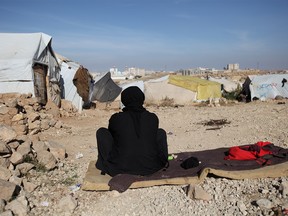 A woman sits in the sun on a cold winter day at a camp for internally displaced people in Khamir of the northwestern province of Amran, Yemen December 16, 2019. Picture taken December 16, 2019. REUTERS/Khaled Abdullah ORG XMIT: HFS-GGGKHA10