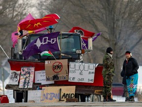 Two people have a conversation at the site of a rail stoppage on Tyendinaga Mohawk Territory, as part of a protest against British Columbia's Coastal GasLink pipeline, in Tyendinaga, Ontario, Canada, February 16, 2020.   REUTERS/Carlos Osorio ORG XMIT: GGGTYE122