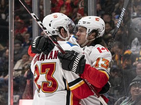 VANCOUVER, BC - FEBRUARY 08: Sean Monahan #23 of the Calgary Flames is congratulated by teammate Johnny Gaudreau #13 after scoring a goal against the Vancouver Canucks during NHL action at Rogers Arena on February 8, 2020 in Vancouver, Canada. (Photo by Rich Lam/Getty Images)