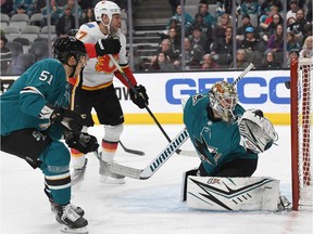 Milan Lucic #17 of the Calgary Flames scores a goal getting his shot past goalie Aaron Dell #30 of the San Jose Sharks during the first period of an NHL hockey game at SAP Center on February 10, 2020 in San Jose, California.