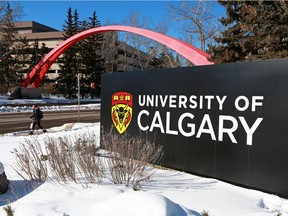 Students walk past a sign at the south entrance to the University of Calgary on Tuesday, Feb. 26, 2019.