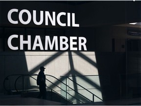Pedestrians at Calgary City Hall are reflected in the glossy wall of council chambers as they walk past on June 3, 2019. Beware the next tax grab at city council, warns columnist Chris Nelson.