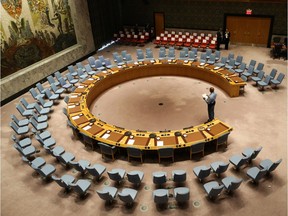 An official looks at the empty chair of leaders ahead of their participation in an open debate of the United Nations Security Council in New York on September 20, 2017. / AFP PHOTO / POOL / Stephane LEMOUTON
