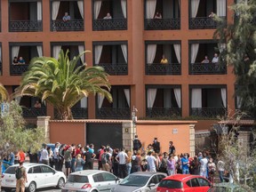 A psychologist talks to a group of workers outside the H10 Costa Adeje Palace Hotel in La Caleta, on Feb. 25, 2020, where hundreds of people were confined after an Italian tourist was hospitalized with a suspected case of coronavirus.