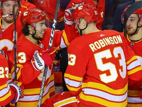 Calgary Flames Buddy Robinson celebrates with teammate Johnny Gaudreau after scoring a goal against the Edmonton Oilers in Calgary on Saturday, Feb. 1, 2020.