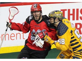The Calgary Roughnecks' Dan MacRae and the Georgia Swarm's Sean Young fight for control during National Lacrosse League action at the Scotiabank Saddledome in Calgary on Saturday March 4, 2017. GAVIN YOUNG/POSTMEDIA NETWORK ORG XMIT: POS1703042219436776