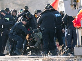 Police make an arrest during a raid on a Tyendinaga Mohawk Territory camp next to a railway crossing in Tyendinaga, Ont., on Monday, Feb. 24, 2020.