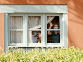 Guests, wearing protective face mask, look through a window at H10 Costa Adeje Palace, which is on lockdown after cases of coronavirus have been detected there in Adeje, on the Spanish island of Tenerife, Spain, February 26, 2020. REUTERS/Borja Suarez