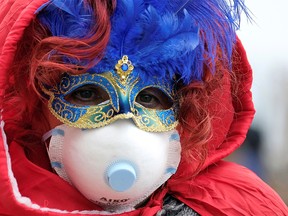 Masked carnival reveller wears protective face mask at Venice Carnival, which the last two days of, as well as Sunday night's festivities, have been cancelled because of an outbreak of coronavirus, in Venice, Italy February 23, 2020.  REUTERS/Manuel Silvestri     TPX IMAGES OF THE DAY ORG XMIT: GGG-MSL109