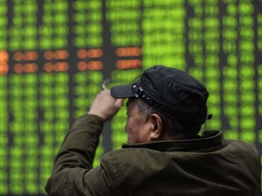 An investor looks at a screen showing stock market movements at a securities company in Hangzhou in China's eastern Zhejiang province on Monday. Chinese stocks crashed with some major shares quickly falling by the maximum daily limit as the country's investors got their first chance in more than a week to react to the spiralling coronavirus outbreak.