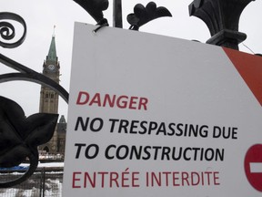 A construction sign hangs on the Queen's Gates on Parliament Hill in Ottawa, Monday January 27, 2020. The experts overseeing the massive restoration of Canada's largest Parliament building have to find out a way to cram more than 100 additional MPs into the House of Commons without compromising its architectural heritage.