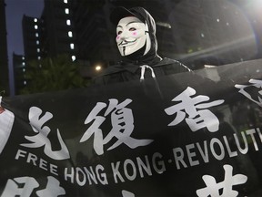 A demonstrator holds a 'Free Hong Kong' banner during a protest against the use of Chun Yeung Estate as a quarantine center in the Fo Tan area of Hong Kong, China, on Sunday, Feb. 16, 2020. Hong Kong is facing "tsunami-like" shocks, and may incur a record budget deficit in the next fiscal year as the city counts the costs of the outbreak after months of social unrest, Financial Secretary Paul Chan said a blog post Sunday. Photographer: May James/Bloomberg ORG XMIT: 775480219