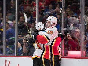Calgary Flames' Matthew Tkachuk (19) and Johnny Gaudreau (13) celebrate Tkachuk's goal against the Vancouver Canucks during the first period of an NHL hockey game in Vancouver, on Saturday February 8, 2020. THE CANADIAN PRESS/Darryl Dyck ORG XMIT: VCRD104