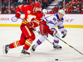 Jan 2, 2020; Calgary, Alberta, CAN; Calgary Flames center Mikael Backlund (11) and New York Rangers defenseman Ryan Lindgren (55) battle for the puck during the first period at Scotiabank Saddledome. Mandatory Credit: Sergei Belski-USA TODAY Sports ORG XMIT: USATSI-405628
