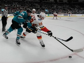 San Jose Sharks defenceman Marc-Edouard Vlasic and Calgary Flames centre Elias Lindholm fight for the puck during the third period at SAP Center at San Jose on Sunday, Oct. 13, 2019.
