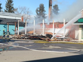 Firefighters continue to pour water on the smouldering remains of the King Edward Hotel in Pincher Creek on Feb. 15, 2020.