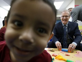 A toddler stares into the camera as the Associate Minister of Red Tape Reduction Grant Hunter plays with kids at the Kids3 Daycare, in Edmonton Tuesday Feb. 4, 2020. Hunter was at the daycare to take part in the announcement of a new online application process for child care subsidies. Photo by David Bloom