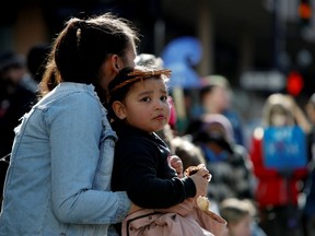 A child sits outside the Business Development Bank of Canada at 1515 Douglas St. as part of a protest against the Coastal GasLink pipeline, in Victoria, British Columbia, Canada February 14, 2020.