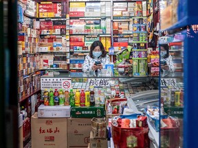 A vendor wearing a protective face mask waits for customers at a shop in Beijing on Feb. 21, 2020.