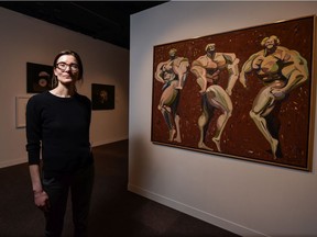 Madeleine Trudeau, co-curator of Metamorphosis: Contemporary Canadian Portraits at the Glenbow Museum, is pictured in front of Harold Town's 1983 oil and lucite portrait Musclemen.