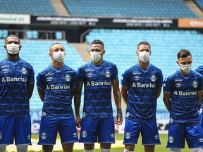 PORTO ALEGRE, BRAZIL - MARCH 15: Players of Gremio wearing masks before the match between Gremio and Sao Luiz as part of the Rio Grande do Sul State Championship 2020, to be played behind closed doors at Arena do Gremio Stadium, on March 15, 2020 in Porto Alegre, Brazil. The Government of the State of Rio Grande do Sul issued a list of new guidelines to help prevent the spread of the Coronavirus which included games played with closed doors and no public. According to the Ministry of Health, as of Saturday, March 14, Brazil had 121 confirmed cases of coronavirus. (Photo by Lucas Uebel/Getty Images)