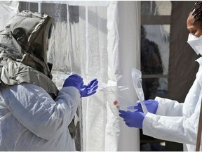 A nurse in a hazmat suit packages a completed test for Coronavirus, Covid-19 to be sent to a lab at Somerville Hospital in Somerville, Massachusetts on March 18, 2020. - Since the virus first emerged in late December, 8,092 people have died around the world, with the global number of cases at 200,680, according to an AFP tally based on official sources as of 1300 GMT Wednesday. (Photo by Joseph Prezioso / AFP)