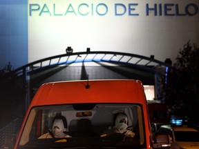 Members of the Spanish Army's Military Emergency Unit (UME) wearing protective suits drive a van outside the Palacio de Hielo (Ice Palace) shopping mall where an ice rink was turned into a temporary morgue on March 23, 2020 in Madrid to deal with a surge in deaths in the Spanish capital due to the coronavirus.
