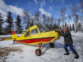 David Reid, a farmer and pilot pushes the plane that his father Richard purchased as a 17-year-old and which he is now restoring, out of a hangar at their farm near Cremona, Alta., Wednesday, March 4, 2020.THE CANADIAN PRESS/Jeff McIntosh