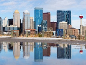 Calgary's downtown skyline is reflected in a large puddle from melting snow on Monday, March 2, 2020.  If you to attract employers, build regional competency profile, says columnist.