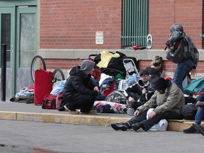 People wait outside the Calgary Drop-In Centre on Monday, March 23, 2020.
