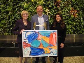 Pictured, from left, at  DLA Piper's 13th annual Art and Martinis, an annual event showcasing  emerging artists from the U of C's Department of Art are Ann Calvert; Richard Sigurdsson, dean of U of C Faculty of Arts; and 4th year student Louisa MacDonald. The art piece, created by MacDonald, is titled Oceanic Daydream.