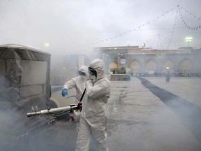 Members of the medical team spray disinfectant to sanitize outdoor place of Imam Reza's holy shrine, following the coronavirus outbreak, in Mashhad, Iran February 27, 2020. Picture taken February 27, 2020. WANA (West Asia News Agency) via REUTERS ORG XMIT: GGGBAG5610