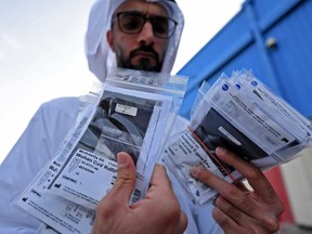 Officials check medical equipment and coronavirus testing kits provided by the World Health Organisation at the al-Maktum International airport in Dubai on Monday as tonnes of aid is prepared to be delivered to Iran with a United Arab Emirates military transport plane. The OECD defined a more intensive outbreak as one that spread “widely” throughout the Asia-Pacific region, Europe and North America and issued its warning as new cases were reported around the world and the death toll continued to climb.