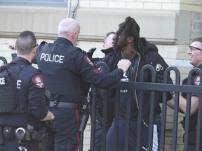 Calgary Police take a man into custody near 13 Ave and 7 St SW following an alleged shooting about 4 blocks away near 17 Ave and 7 St SW in downtown Calgary on Sunday, March 22, 2020. No injuries were reported by cops may have found shell casings in an alley. Jim Wells/Postmedia