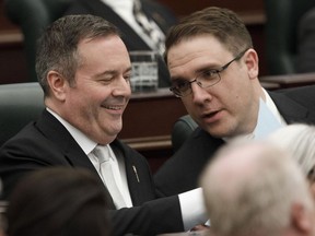 Alberta Premier Jason Kenny Jason Nixon Minister of Environment and Parks chat before the speech from the throne is delivered in Edmonton Alta, on Tuesday May 21, 2019. Alberta politicians are heading back into the legislature to pass emergency bills and set new rules on their own social distancing during the COVID-19 outbreak.