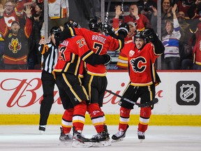 Flames Sean Monahan, T.J. Brodie and Johnny Gaudreau celebrate Brodie's overtime goal against the Columbus Blue Jackets at Scotiabank Saddledome on March 4, 2020.