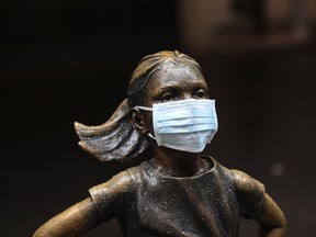 A surgical mask is placed on The "Fearless Girl" statue outside the New York Stock Exchange on Thursday, March 19, 2020, in New York.