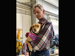 Jerry Hogg with BARCS holds Honey who was skittish after a flight from California with Pet Rescue Pilots landed in Calgary on March 8, 2020. Stephanie Babych / Postmedia