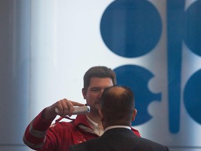 Guarding against COVID-19, a Red Cross medic measures the temperature of a participant of the 178th Organization of Petroleum Exporting Countries (OPEC) meeting in Vienna, Austria, on March 5, 2020.