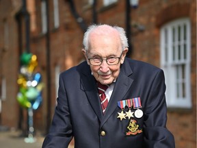 British World War II veteran Captain Tom Moore, 99, poses doing a lap of his garden in the village of Marston Moretaine, 50 miles north of London, on April 16, 2020. - A 99-year-old British World War II veteran Captain Tom Moore on April 16 completed 100 laps of his garden in a fundraising challenge for healthcare staff that has "captured the heart of the nation", raising more than £13 million ($16.2 million, 14.9 million euros). "Incredible and now words fail me," Captain Moore said, after finishing the laps of his 25-metre (82-foot) garden with his walking frame. (Photo by JUSTIN TALLIS / AFP)
