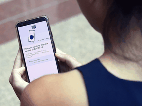 A woman demonstrates Singapore's contact-tracing smarthphone app called Trace Together, as a preventive measure against the COVID-19 coronavirus, March 20, 2020. Alberta's app was built from the same source code as Singapore's app.