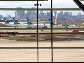 Parked WestJet planes are seen through the windows of the Calgary International airport which was almost deserted amid the COVID-19 pandemic on Wednesday, April 29, 2020.