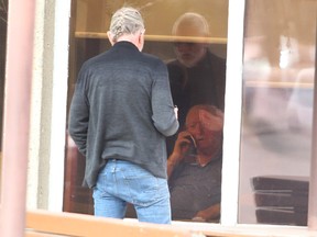 A man is seen speaking with a resident of the Clifton Manor long-term care home in the SE via cellphone.