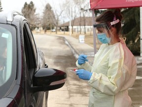 Dr Amelia Leskiw takes COVID-19 samples at a drive thru location in High River, AB, south of Calgary on Friday, April 17, 2020. There will be an larger off site up an running in the town on Monday. Jim Wells/Postmedia