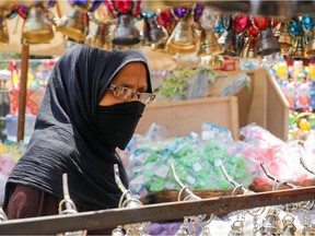 Muslims around the world are preparing for a different Ramadan this year. Here, a woman wearing a protective face mask, amid concerns over the coronavirus disease (COVID-19) buys traditional Ramadan lanterns, called "Fanous" which are displayed for sale at a stall, ahead of the Muslim holy month of Ramadan in Cairo, Egypt, April 12, 2020. REUTERS/Mohamed Abd El Ghany ORG XMIT: GGG-GHA04