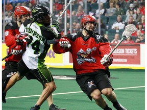 The Calgary Roughnecks' Tyler Burton, right and Curtis Manning move the ball between the Saskatchewan Rush's Jeremy Thompson during National Lacrosse League action at the Scotiabank Saddledome in Calgary on Saturday February 4, 2017. GAVIN YOUNG/POSTMEDIA