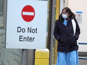 A healthcare worker is seen outside the Rockyview General Hospital's emergency entrance as Calgary endures the COVID-19 pandemic.  Tuesday, April 7, 2020. Brendan Miller/Postmedia