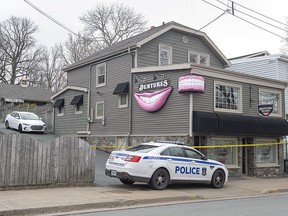 The Atlantic Denture Clinic is guarded by police in Dartmouth, N.S., on Monday, April 20, 2020. The business is owned by Gabriel Wortman, who killed 16 people during a mass shooting on the weekend. Wortman, 51, was shot and killed by police.